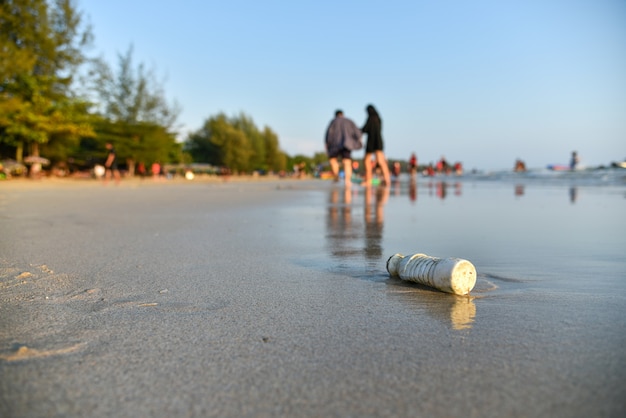 Garrafa na praia suja.