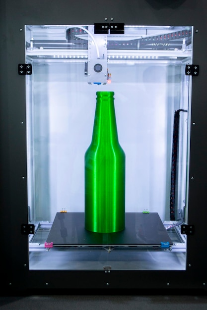Garrafa verde do objeto impressa na impressora 3D fechada dentro da impressora 3d