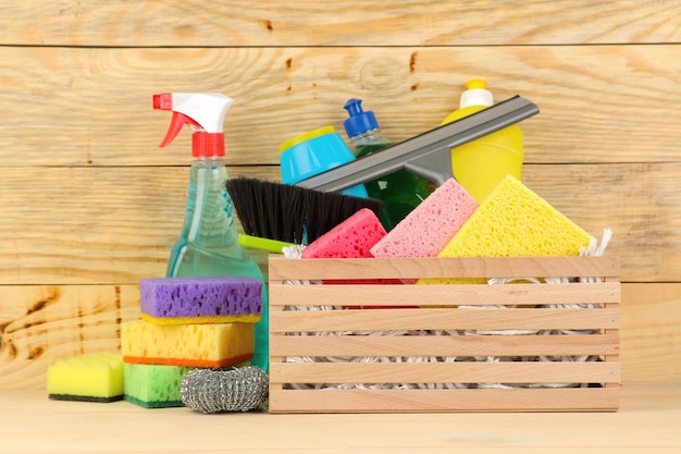 Garrafas com detergente e ferramentas de limpeza em uma gaveta em produtos de limpeza de fundo de madeira natural