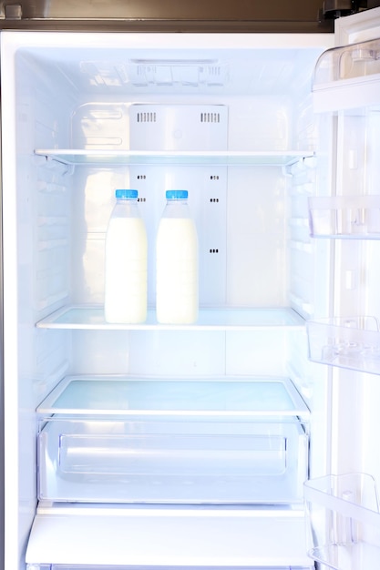Garrafas com leite na geladeira