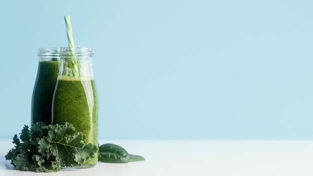 Garrafas com smoothie verde e espaço de cópia