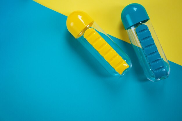garrafas de água azuis e amarelas em fundo azul e amarelo