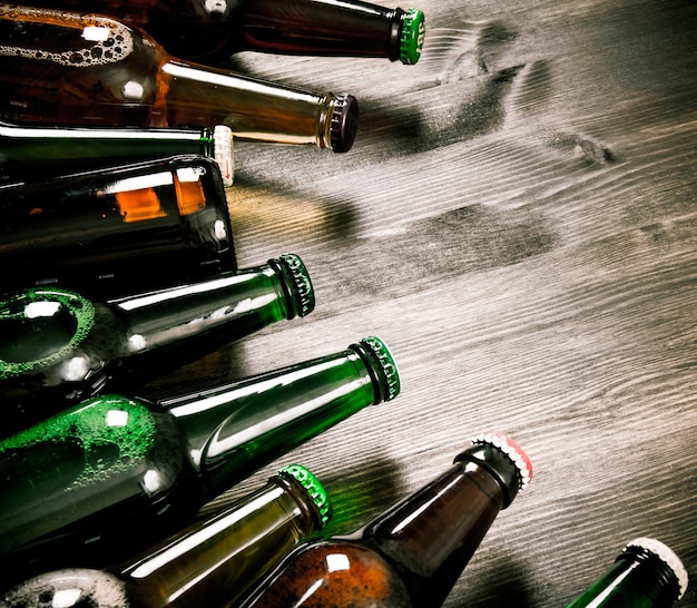 Foto garrafas de cerveja em uma mesa de madeira. cerveja escura