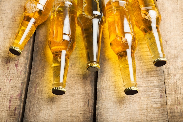 Garrafas de cerveja em uma mesa de madeira.