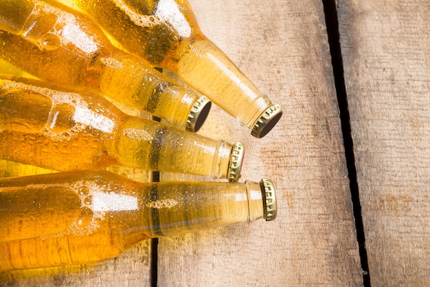 Foto garrafas de cerveja em uma mesa de madeira.