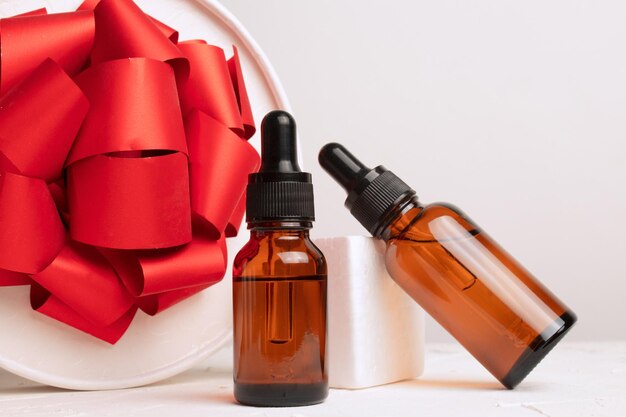 Garrafas de cosméticos para cuidados com a pele em um fundo branco presente de Natal para mulheres Cosméticos da temporada de inverno