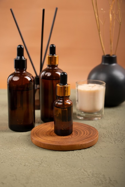 Garrafas de vidro de âmbar e vela para exibição de produtos orgânicos de cuidados com a pele