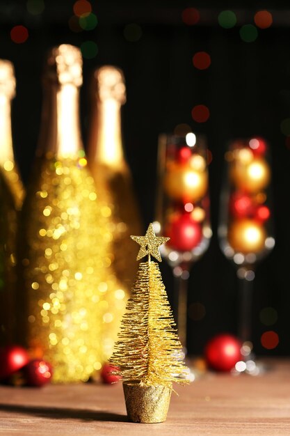 Garrafas decorativas de champanhe com bolas de Natal em fundo escuro