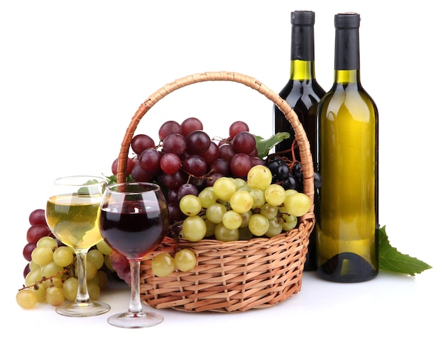 Garrafas e taças de vinho e uvas na cesta isoladas em branco