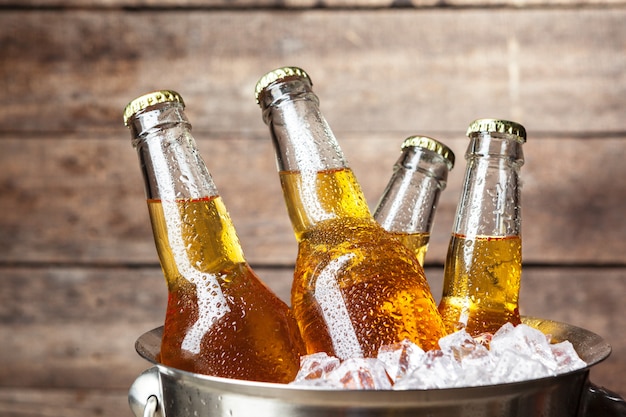 Foto garrafas frias de cerveja em um balde