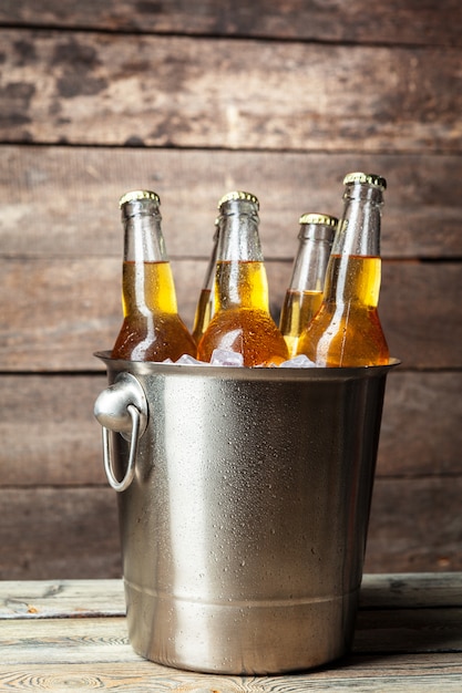 Foto garrafas geladas de cerveja no balde na madeira