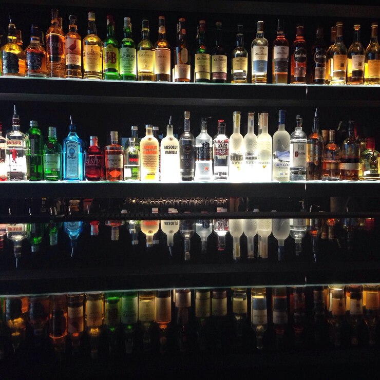 Foto garrafas na prateleira do bar.
