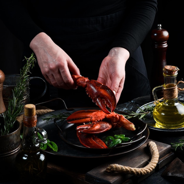 Garras de lagosta de frutos do mar em um prato nas mãos do chef Food banner