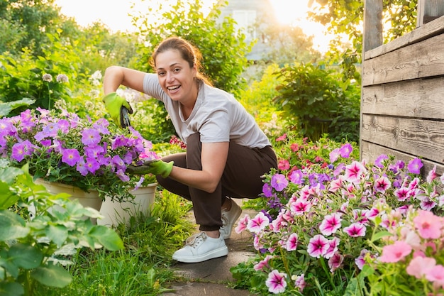 Garten- und Landwirtschaftskonzept Junge Landarbeiterin gärtnert Blumen im Garten Gärtner pflanzt Blumen für Blumenstrauß Sommergartenarbeit Mädchen arbeiten zu Hause im Hinterhof im Garten