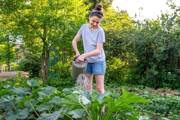 Gartenarbeit Landwirtschaft Konzept Gärtnerin Landarbeiterin, die Gießkanne hält und Bewässerung bewässert