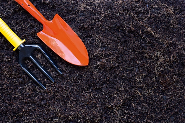 Gartenschaufel und Gabel auf Boden mit dem Haar der Kokosnussschale für die Landwirtschaft.