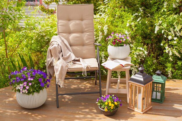 Gartenstuhl auf Terrasse und Stiefmütterchen Blumen