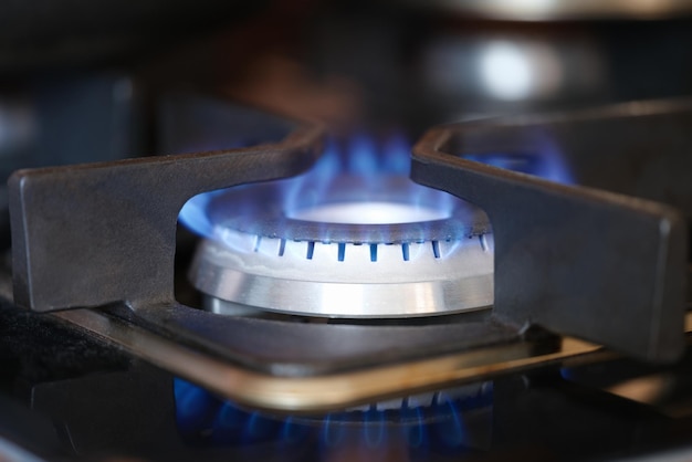 Gasbrenner auf Herd mit blauem Feuer zu Hause in der Nähe