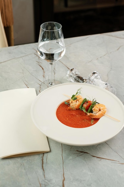 Gaspacho com camarão Servindo comida em restaurante com copo de água e cardápio