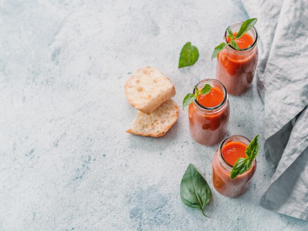 Foto gaspacho soup in glass bottles copy space