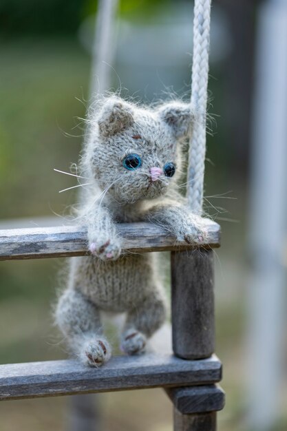 Gatinho de brinquedo de malha cinza na natureza