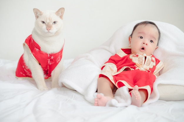 Gato y bebé vistiendo traje rojo chino