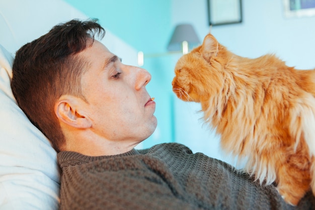 Gato comendo comida da boca de uma pessoa