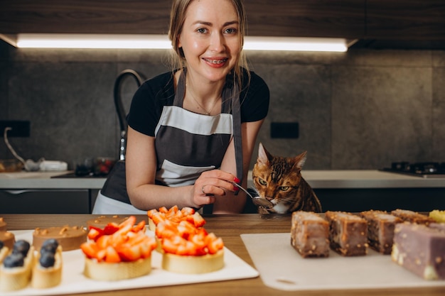 Gato de Bengala engraçado na cozinha vestido como cozinheiro