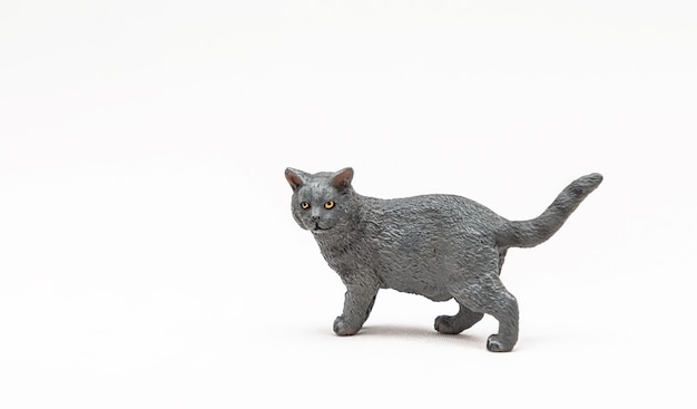 Gato de brinquedo de plástico realista isolado na superfície branca. pequeno animalzinho fofo para crianças