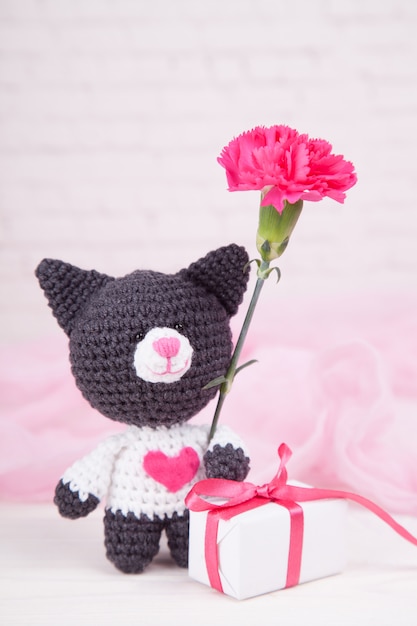 Gato de punto con un corazón. Decoración de San Valentín. Juguete de punto, amigurumi. Tarjeta de felicitación del día de San Valentín.