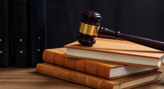 Gavel do juiz na mesa de madeira dos livros de direito