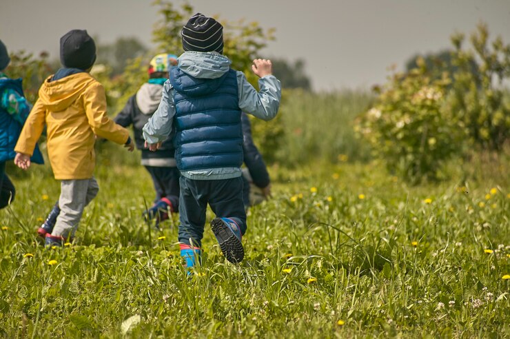GAVELLO, ITÁLIA, 23 DE MARÇO DE 2020: As crianças brincam ao ar livre, cercadas por grama verde e natureza no campo