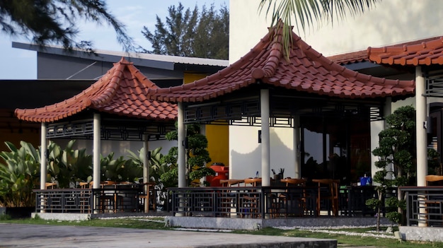 Gazebo abierto oriental o pabellón con mesa y silla para sentarse para que amigos y familiares se reúnan y compartan comida blanca