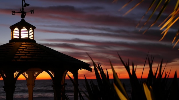 Gazebo de cloudscape al atardecer en la playa crepúsculo atardecer dramático cielo alcoba y veleta