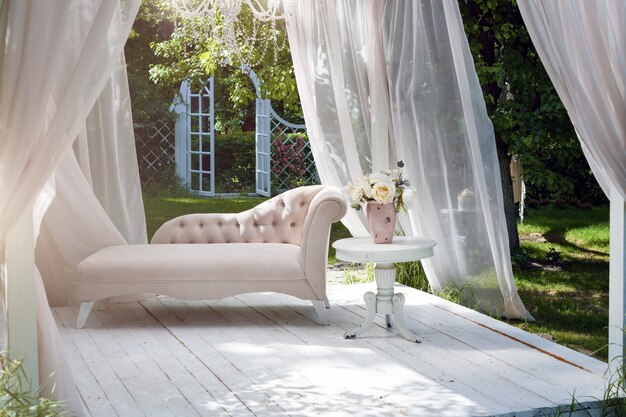 Gazebo de jardim de verão com cortinas e sofá