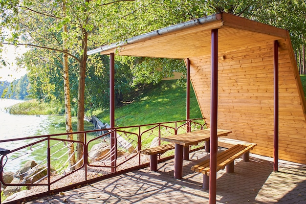 Gazebo de madeira com telhado na margem do lago