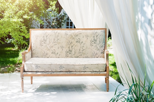 Gazebo moderno de luxo com móveis macios e cortinas dentro do jardim. pavilhão de cerimônia de casamento de verão.