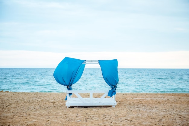 gazebo na praia ao pôr do sol com cortinas azuis dobráveis sem pessoas