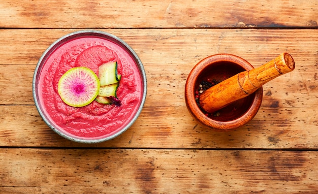 Gazpacho oder kalte Rote-Bete-Püree-Suppe mit Daikon.Kalte Sommerrübensuppe auf dem alten hölzernen Hintergrund