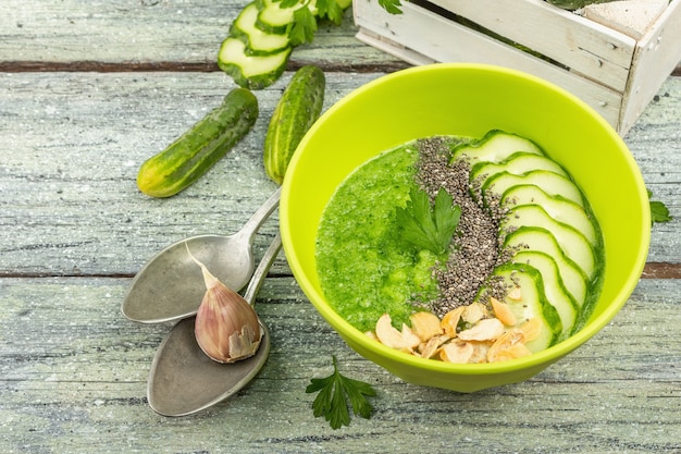 Gazpacho de Pepino. Sopa de verano fría fresca verde. Verduras frescas, verduras, especias y cubiertos. Fondo de tablas de madera vieja, cerrar