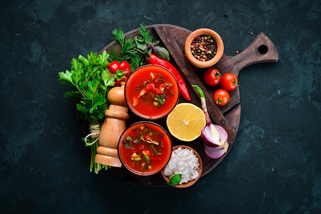 Gazpacho-Suppe im Glas. Tomatensuppe mit Zwiebeln, Paprika und Petersilie. Italienische Küche. Ansicht von oben. Auf schwarzem Hintergrund. Freier Platz für Text.