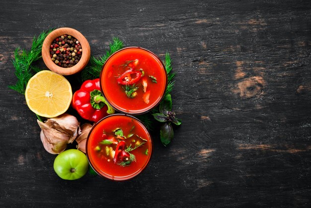 Gazpacho-Suppe im Glas. Tomatensuppe mit Zwiebeln, Paprika und Petersilie. Italienische Küche. Ansicht von oben. Auf schwarzem Hintergrund. Freier Platz für Text.