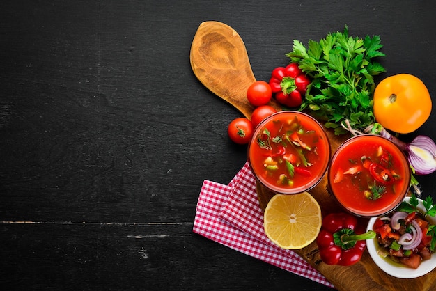 Gazpacho-Suppe im Glas Tomatensuppe mit Zwiebeln, Paprika und Petersilie italienische Küche Draufsicht auf schwarzem Hintergrund Freier Platz für Text