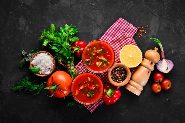 Gazpacho-Suppe im Glas Tomatensuppe mit Zwiebeln, Paprika und Petersilie italienische Küche Draufsicht auf schwarzem Hintergrund Freier Platz für Text