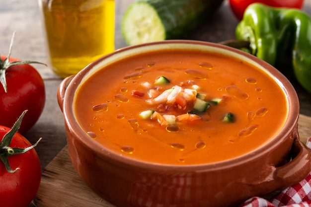 Gazpacho-Suppe im Topf und Zutat auf Holztisch