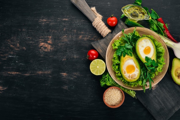 Gebackene Avocado mit Ei Gesundes Essen Auf einem hölzernen Hintergrund Ansicht von oben Kopieren Sie Platz