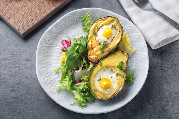 Gebackene Avocado mit Eiern und Gemüse auf dem Tisch