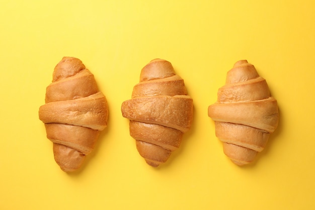 Gebackene Croissants auf gelbem Hintergrund, Draufsicht