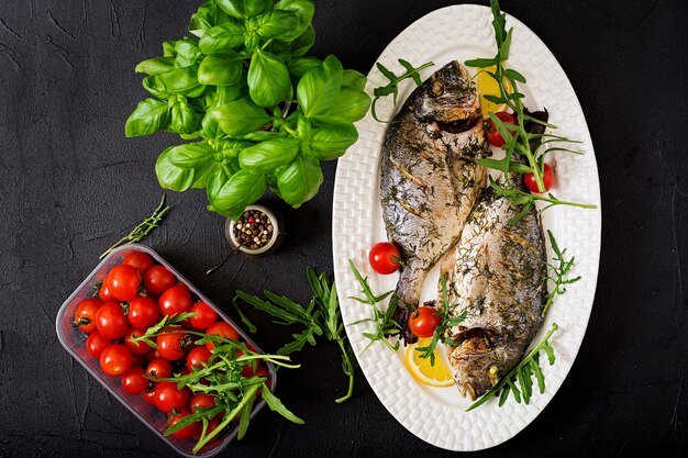 Gebackene Dorado-Fische in Knoblauch-Dill-Sauce und Zitrone.