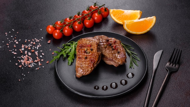 Gebackene Entenbrust mit Kräutern und Gewürzen auf einem dunklen Tisch. Gebratenes Fleisch verzehrfertig